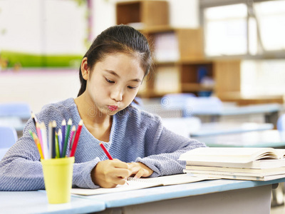 小学快乐的学生,同在一个教室里竖起大拇指可爱的小孩在教室里做作业.