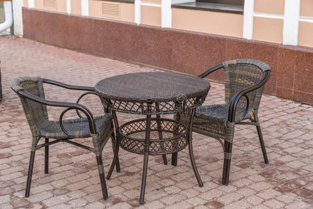 。 柳条桌子和椅子在城市街道上的空咖啡馆里