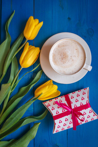 咖啡杯，黄色郁金香花和礼物