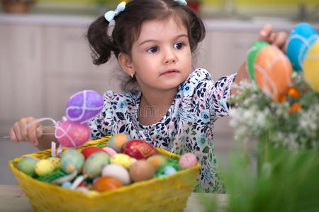 可爱的小女孩，篮子里装满了五颜六色的复活节彩蛋