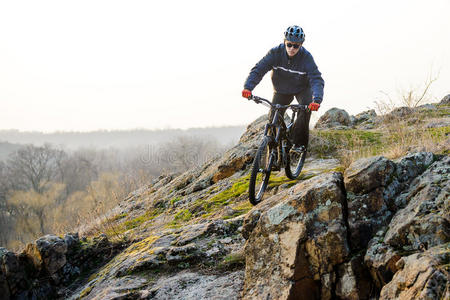恩杜罗自行车手骑着山地车沿着美丽的岩石小径走下去。 极限运动概念。 文本的空间。
