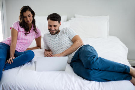 夫妇在卧室里用笔记本电脑