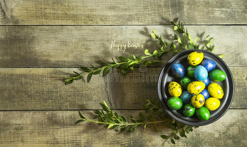 复活节彩蛋放在木制背景上的碗里