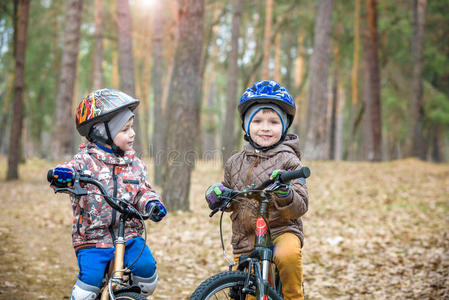 清晨，孩子骑自行车在森林里。 男孩骑自行车