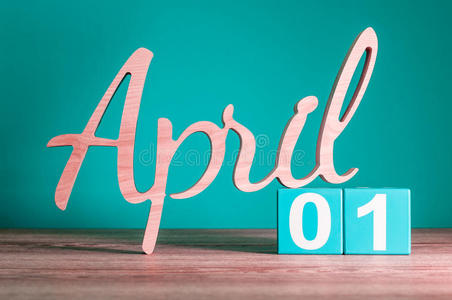 每月第一天,每日日历在木桌上绿色背景. 春天的主题照片