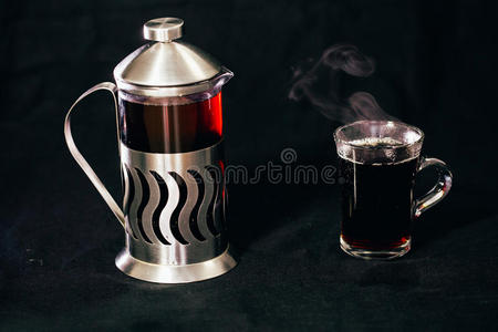 法国压力机与茶和透明的一杯茶在黑色背景