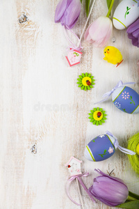 花束紫色郁金香和复活节鸡蛋在一个轻木桌上。