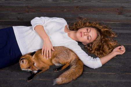 以前现在一个年轻漂亮的女孩抱着一只野生狐狸动物,被一个男人创伤,被