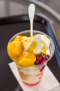 美味芒果美味的芒果冰淇淋圣代在塑料杯里照片