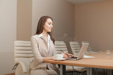 女商人在办公室工作，使用笔记本电脑