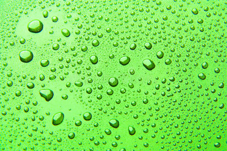 彩色背景上的水滴。 绿色