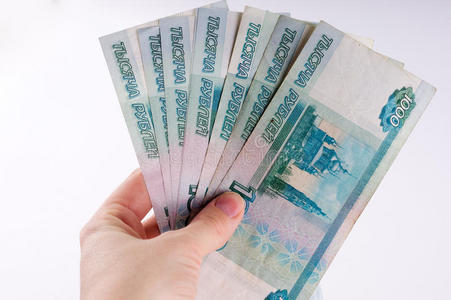 一只手拿着一堆一千美元的卢布钞票. 俄罗斯铜照片