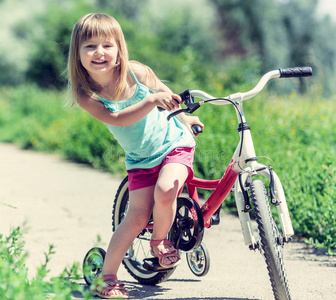 公园里骑自行车的可爱小女孩