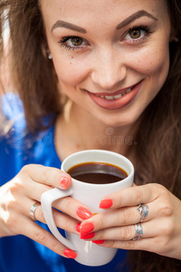 美丽微笑的女人喝了一杯咖啡