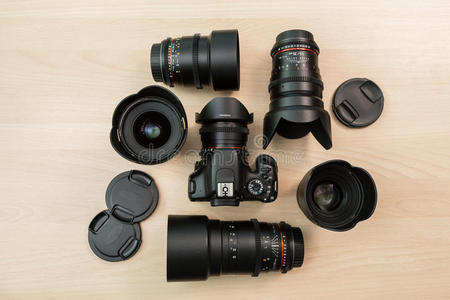 数字SLR相机和几个可互换的手动镜头。 电影制作的设备。 木桌