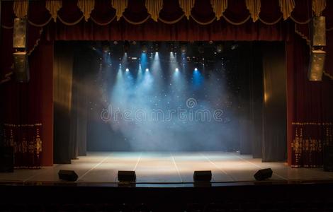 照亮剧院剧院的一个空舞台,由聚光灯和烟雾照亮照片