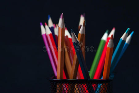 一群五颜六色的削尖铅笔在黑色上