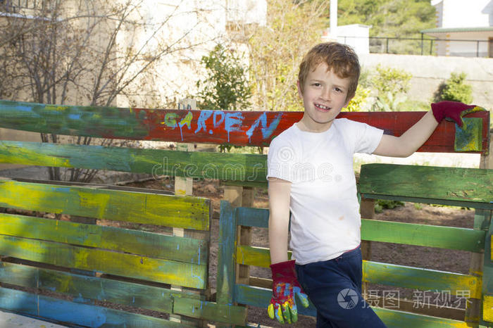 男孩在花园里画篱笆