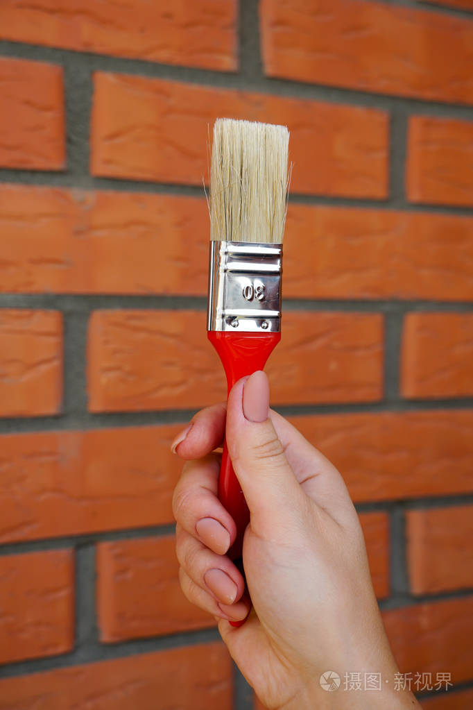 女孩用手在ba上画墙壁用的刷子