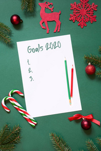 2020年新年目标，规划，白纸上的临终活动，写给圣诞老人的信，绿色背景上的愿望清单。俯视图。