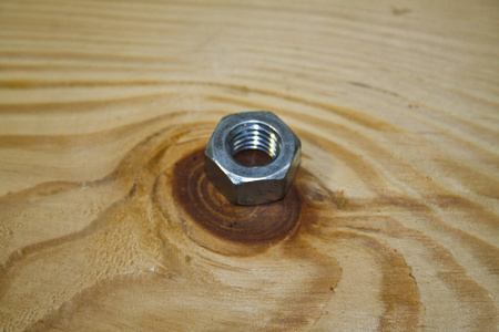 木制背景上隔离的螺母螺栓