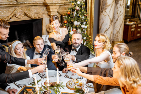 Elegantly dressed people celebrating New Year holiday indoors