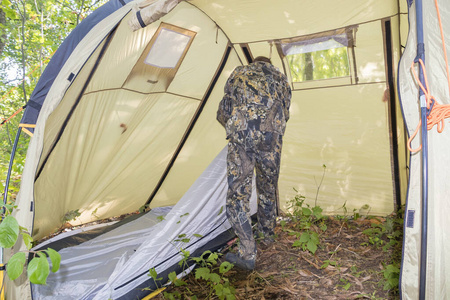 一个男人在森林里的未来营地的遗址上搭起了帐篷