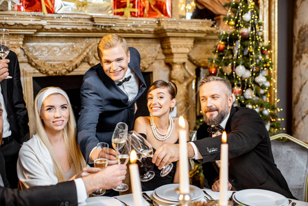 Elegantly dressed people celebrating New Year holiday indoors