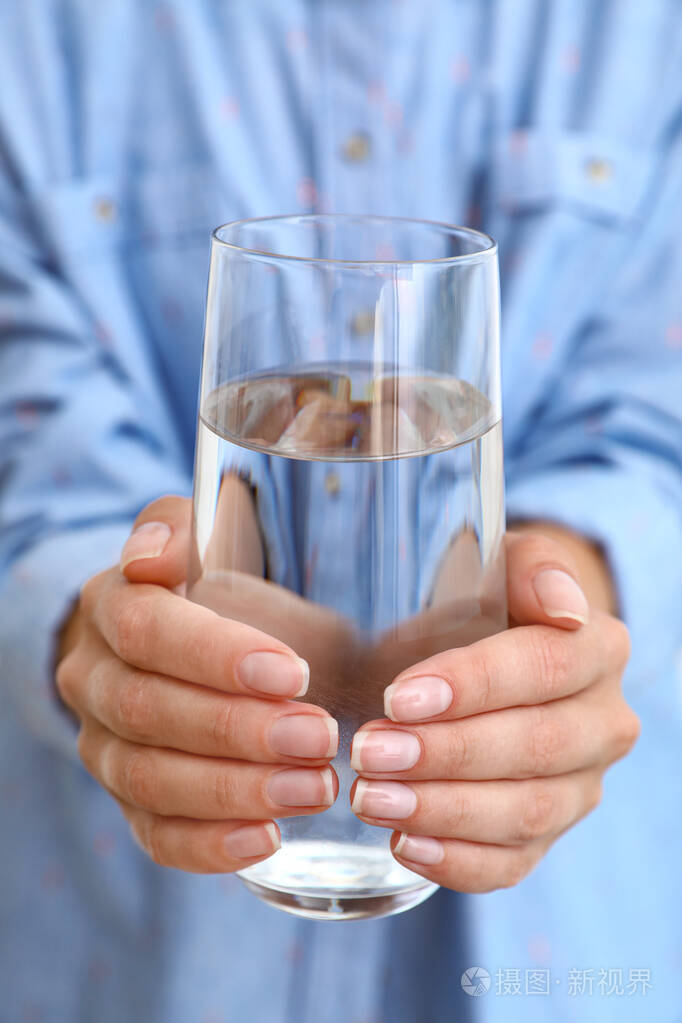 女人拿着一杯水特写提神饮料