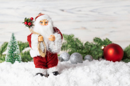 圣诞装饰圣诞老人玩具，冷杉树枝，闪闪发光的球和雪。
