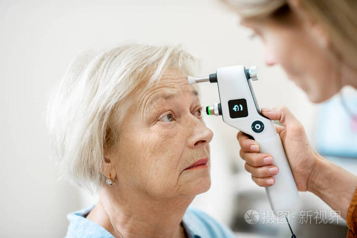 眼科医生给一位老年妇女测量眼压