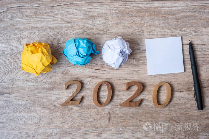 2020年新年用空白的黄色纸条和碎纸在木头上