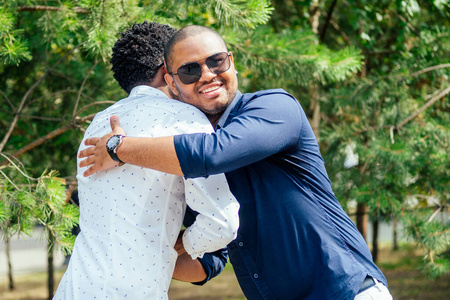 两位时尚的年轻朋友在街边停车场拥抱期待已久的见面会照片