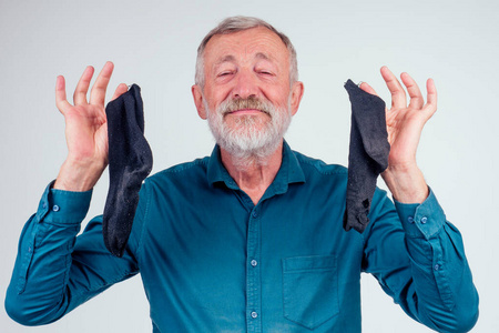 好臭头肩肖像一个老人拿着好臭干净的袜子织物柔软剂工作室白色背景