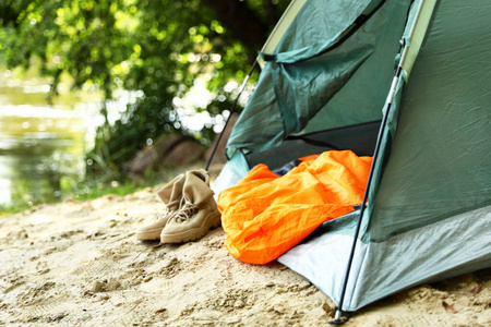 海滩上有睡袋和靴子的露营帐篷