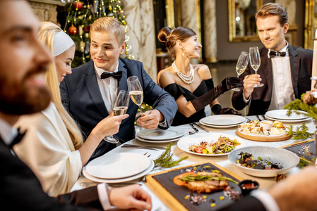 Elegantly dressed people celebrating New Year holiday indoors