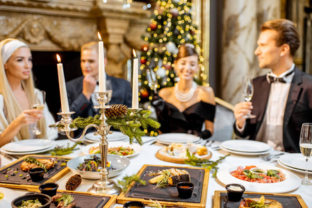 Elegantly dressed people having a festive dinner indoors