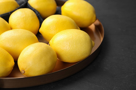 深色桌子上的新鲜成熟柠檬，特写