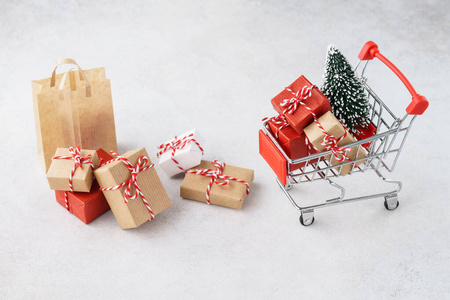 装满礼品盒和圣诞树的购物车或手推车。