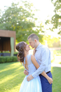 年轻的白人新娘在公园亲吻新郎。
