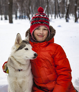 冬天在户外和狗或哈士奇玩耍的男孩。