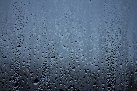 Rain drops on window glasses surface with sky cloudy background 