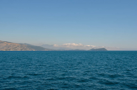  View of greek island against clear blue sky from ferry  . Greec