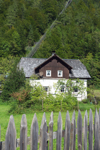 奥地利哈尔施塔特市一座木制栅栏后面的传统的奥地利老房子。背景是一个缆索。旅行。