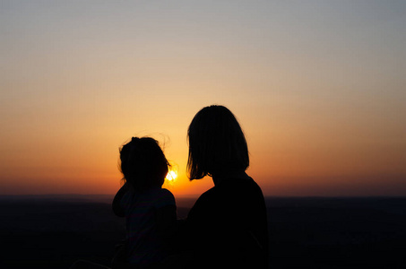 妈妈和女儿在夕阳下放松。