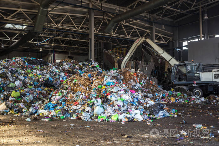 在现代垃圾分类回收处理厂挖掘机把垃圾堆成一堆分离和分类垃圾收集
