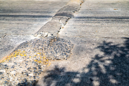 邦市中午沥青路面裂缝减速带特写颠簸的混凝土道路减速带减速带停车场