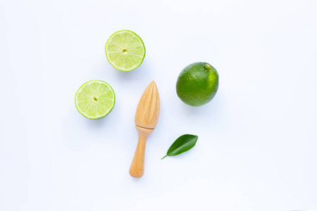 Fresh limes with wooden juicer on white background. 