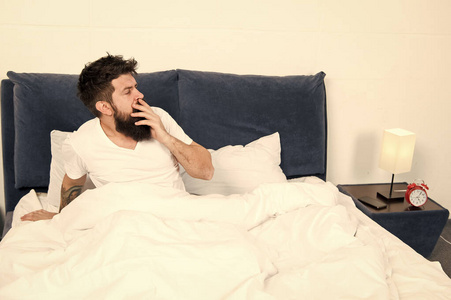 大胡子男人早上睡觉.在床上穿着睡衣留着胡子的成年男性.