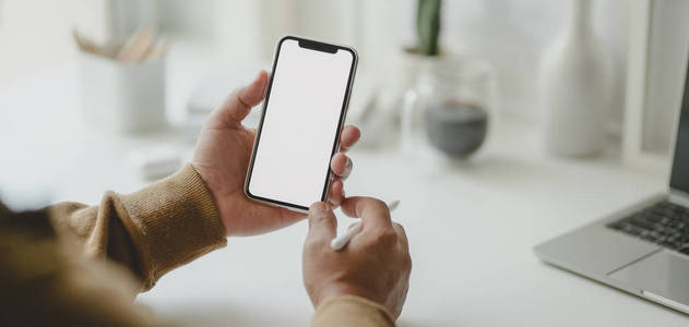 Cropped shot of young male freelancer holding blank screen smart